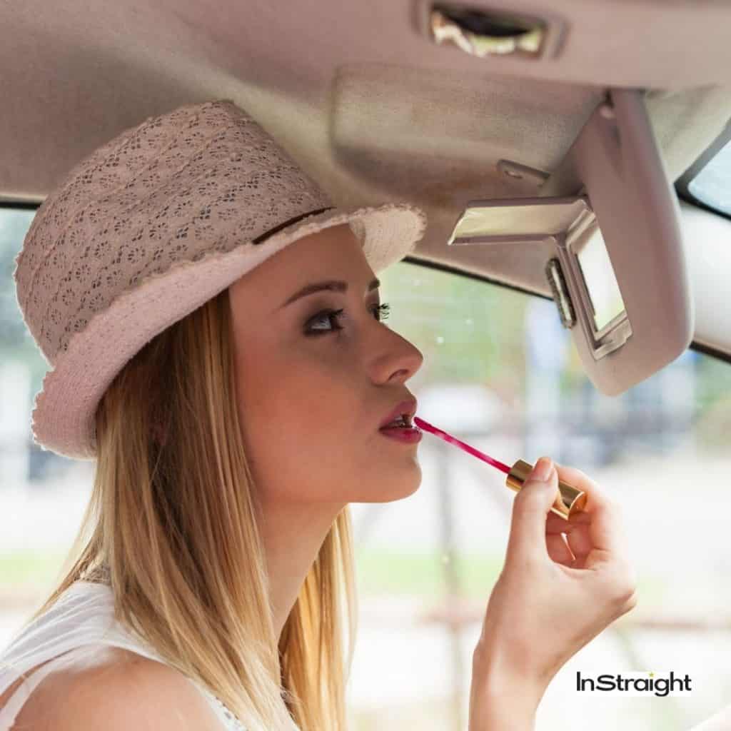 girl applying lipgloss in a car under title Are LED Makeup Mirrors Bad For Your Eyes?